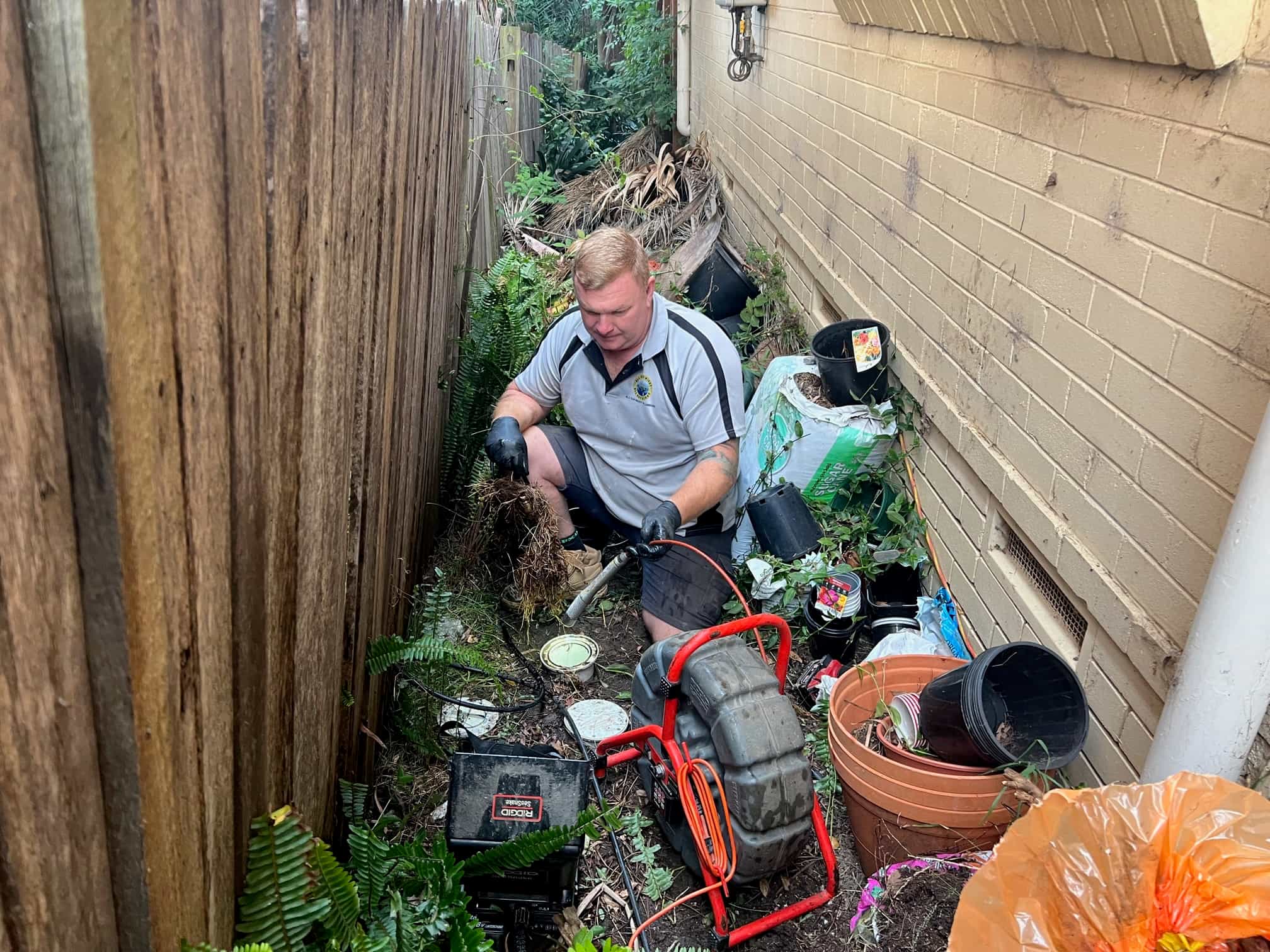 Scott Johnstone clearing roots from an outdoor drain access