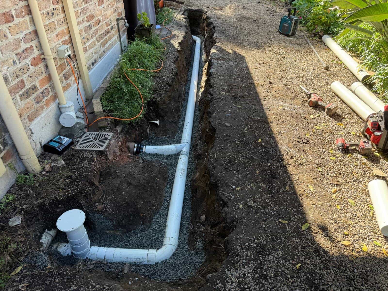 Finished drainage pipework beside a home after repair work