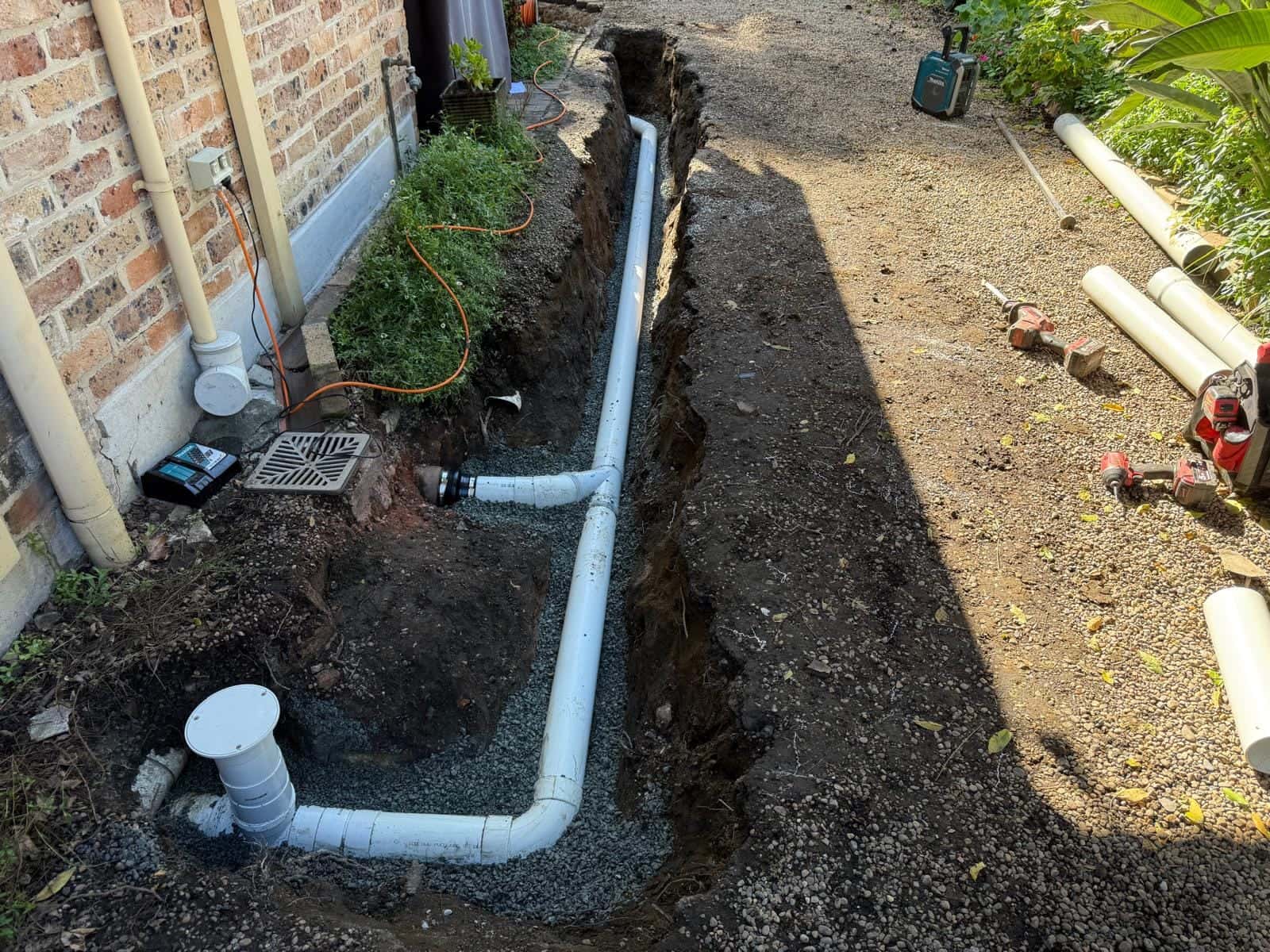 Finished drainage pipework beside a home after repair work