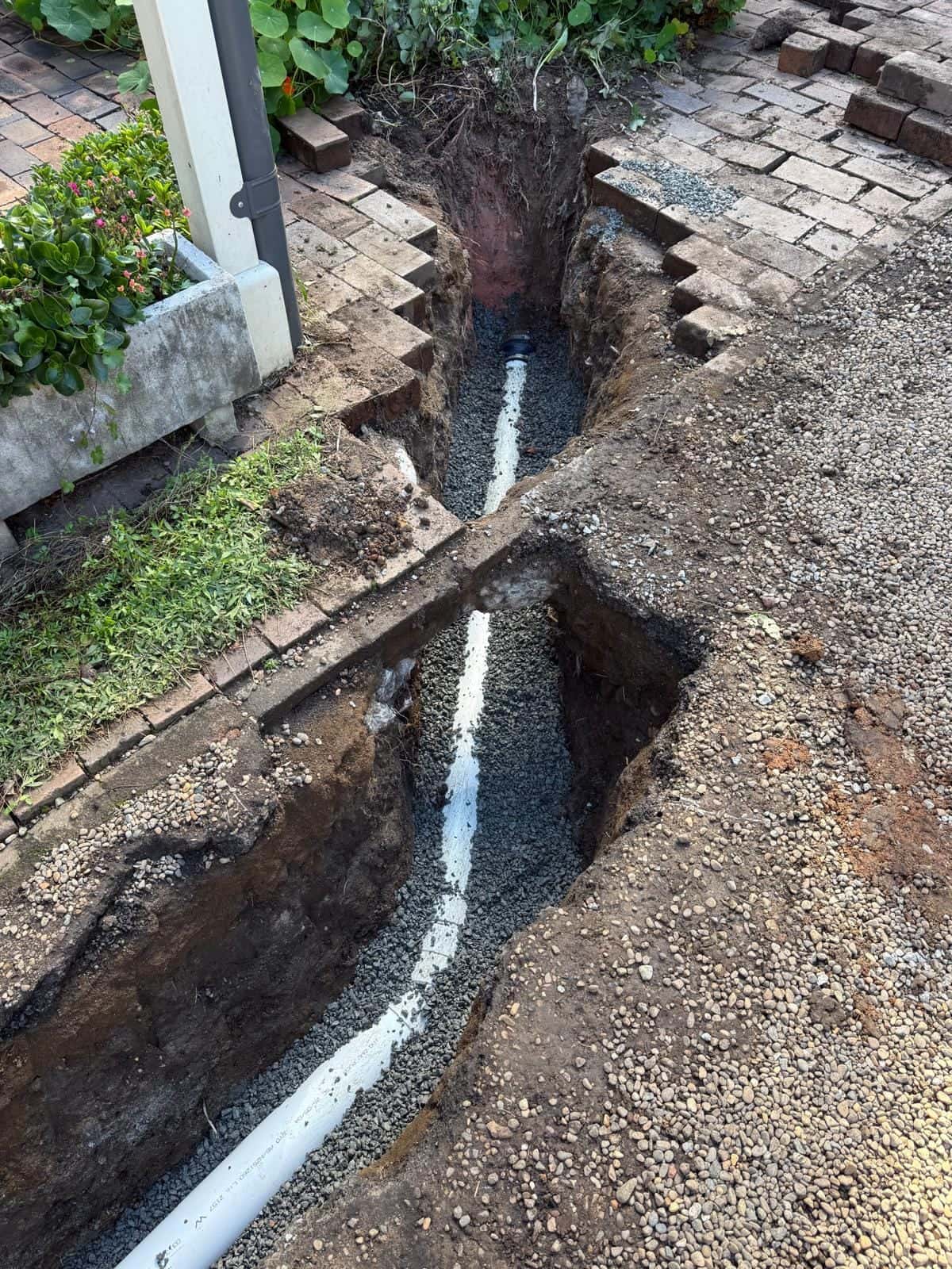 Drainage trench filled with gravel after pipework is placed
