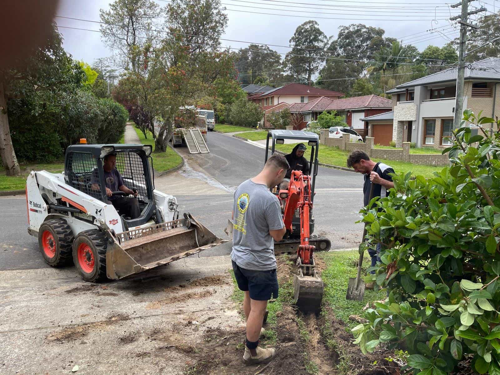 Excavator and drainage equipment working outside a Sydney home