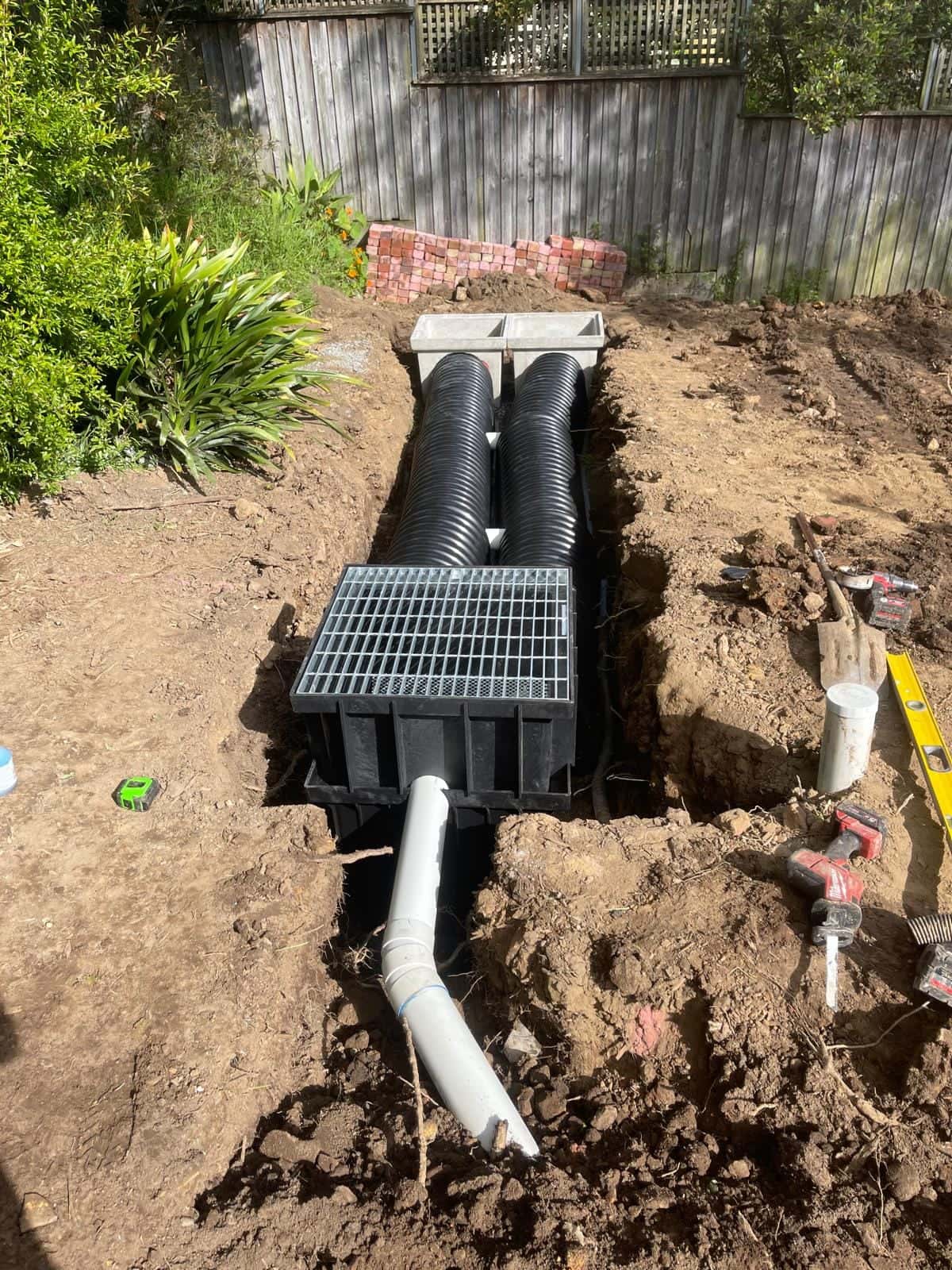 Twin stormwater pits and drainage pipework installed in a trench