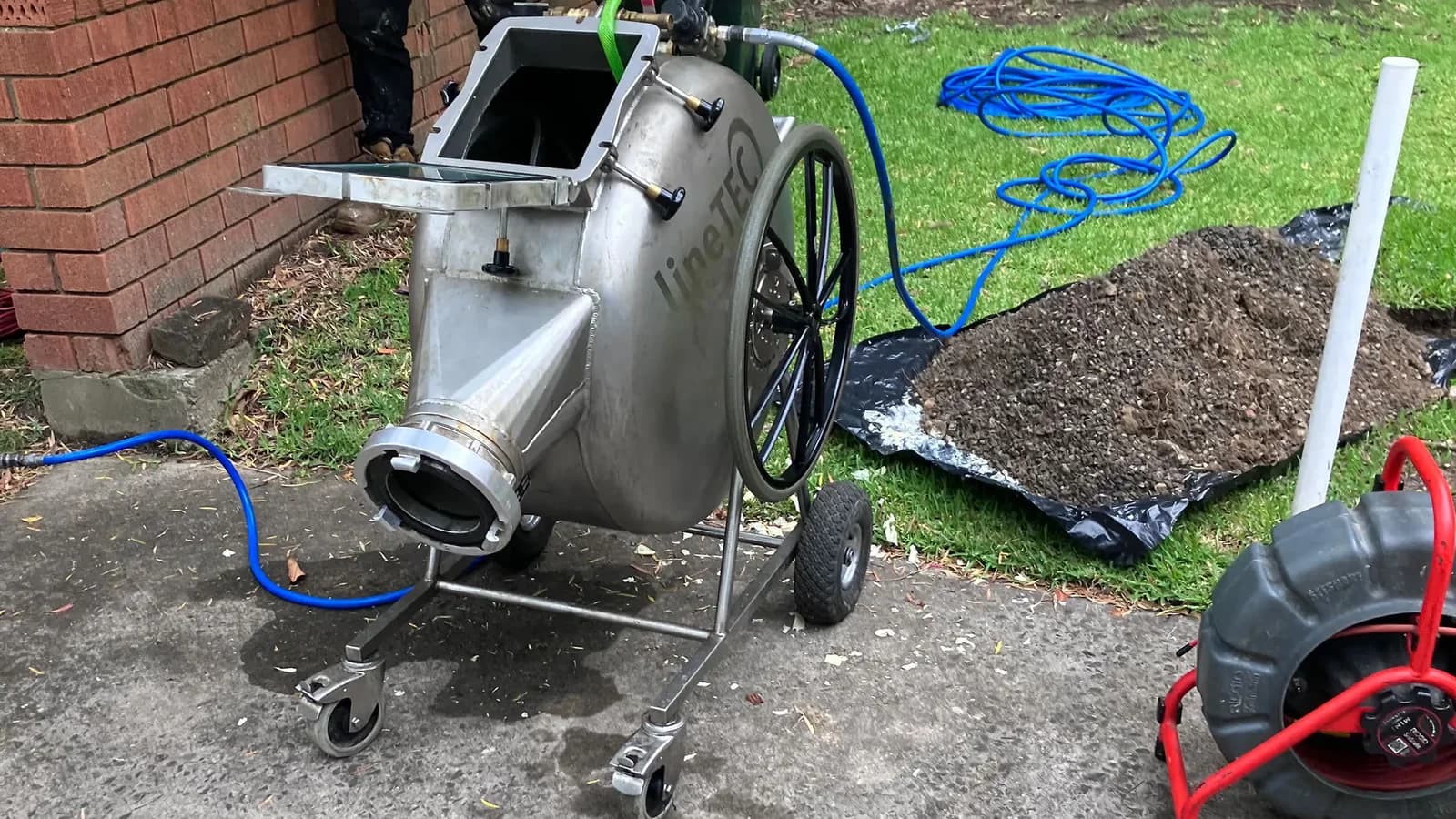 Hydro jetting equipment set up beside an outdoor drain access