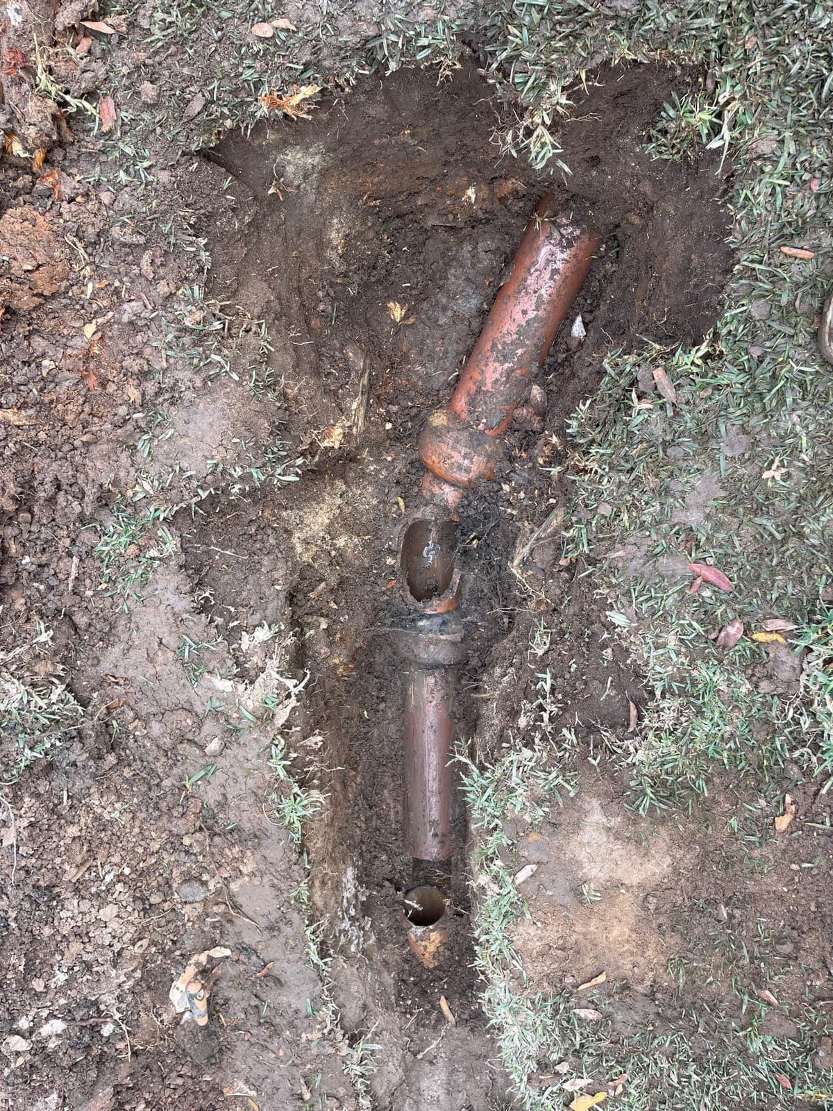 Drain pipe junction exposed in soil during access work