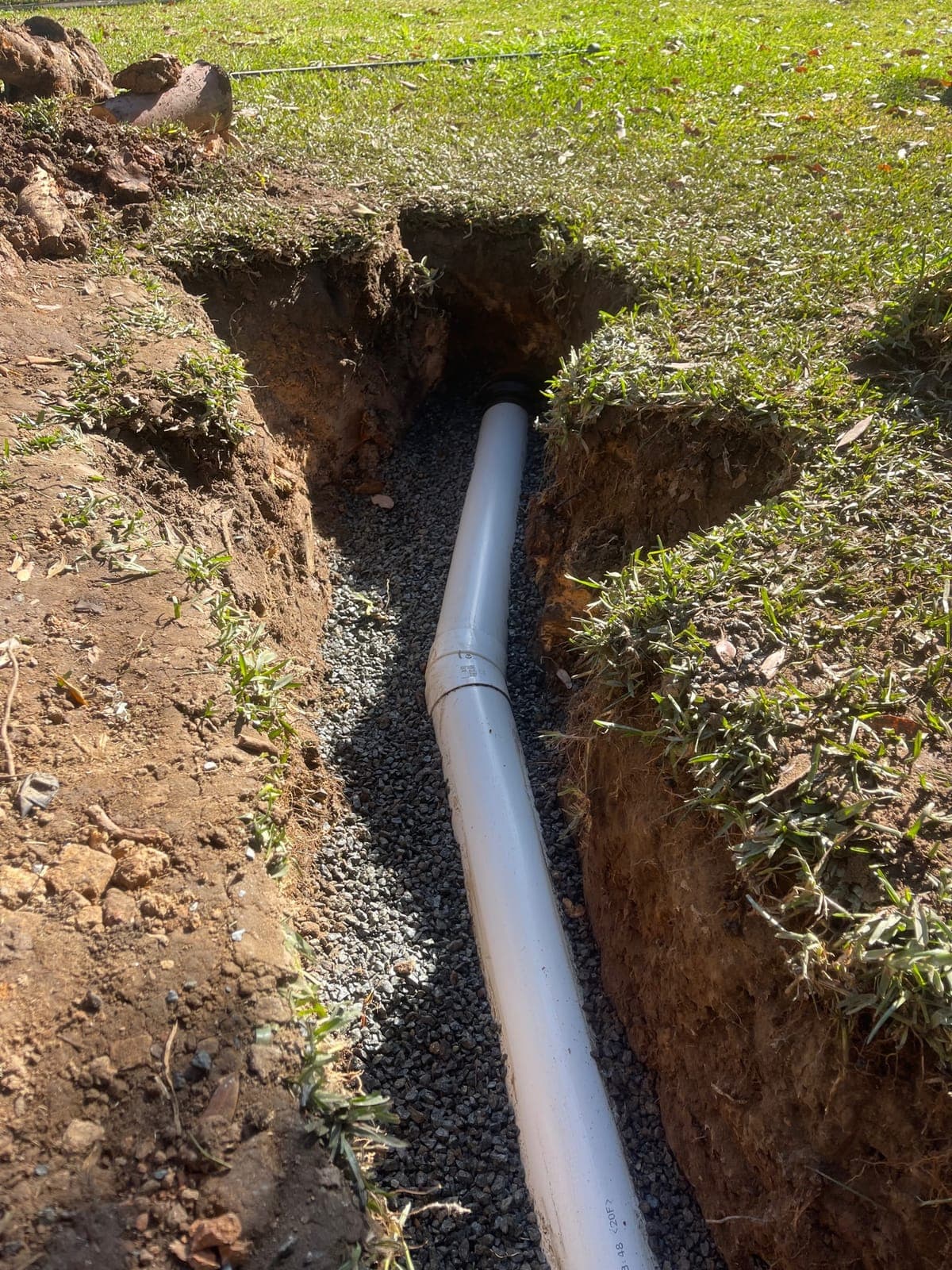 Second view of new drain pipework set in a trench