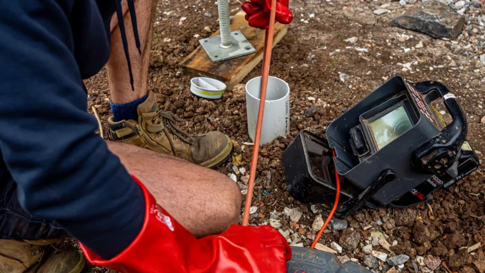 CCTV drain camera cable feeding into an outdoor pipe access point