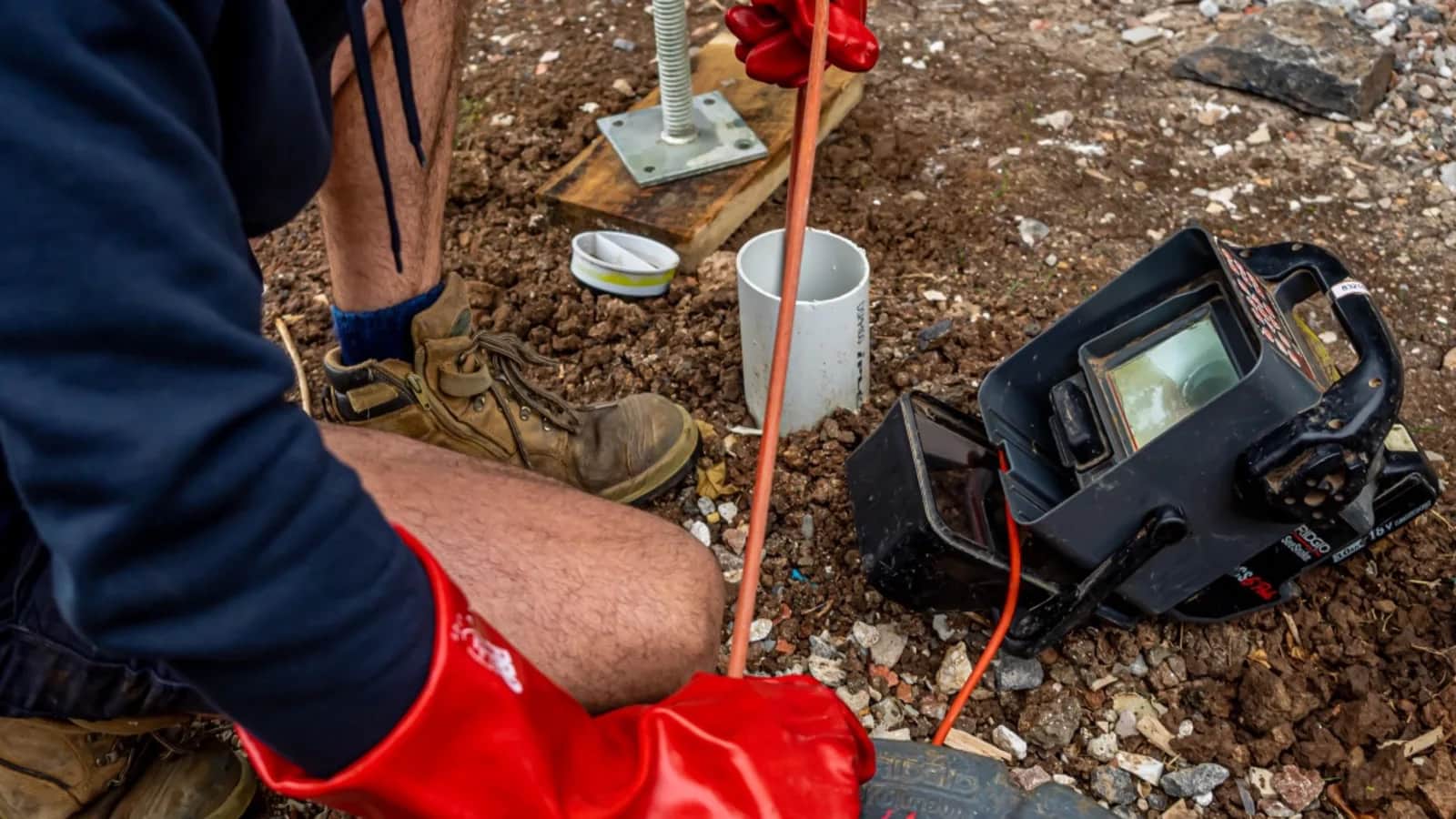 CCTV drain camera cable feeding into an outdoor pipe access point
